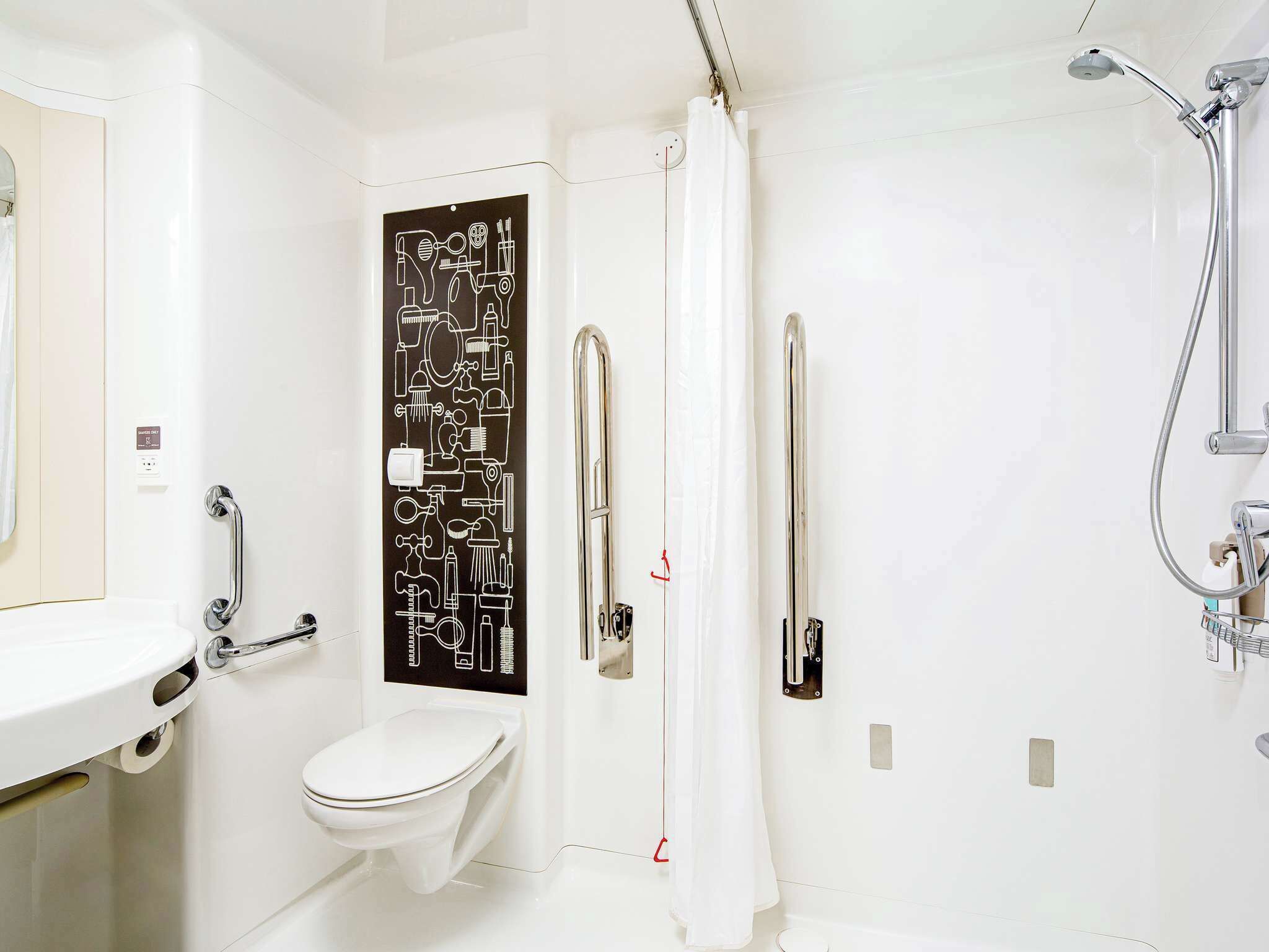 A modern bathroom with a toilet, a shower, and a sink.