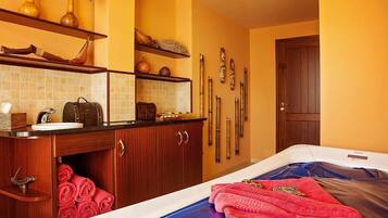 Una habitación de hotel con un tocador de madera, una cama con ropa de cama azul y un perchero para esquíes en la pared.