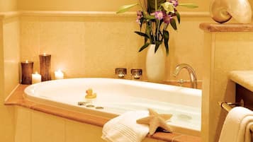 A bathroom with a bathtub, a starfish decoration, a rubber duck, and a vase with flowers.