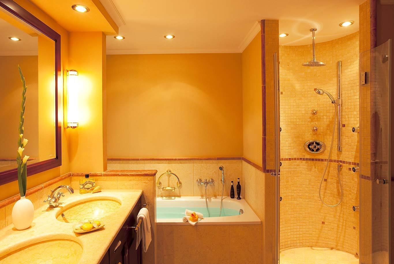 A modern bathroom with dual sinks, a large bathtub, and a walk-in shower.