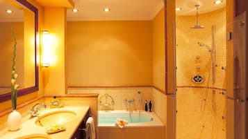 A modern bathroom with dual sinks, a large bathtub, and a walk-in shower.