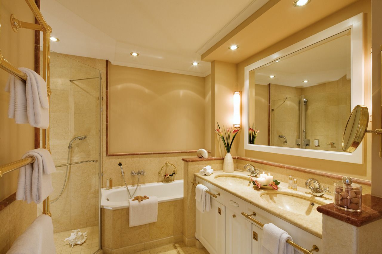 A modern bathroom with a large mirror, a bathtub, and a shower area.