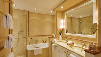 A modern bathroom with a large mirror, a bathtub, and a shower area.