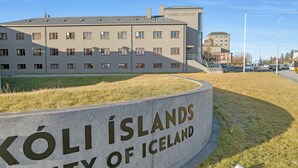 Señal de las ISLAS KOLI en ISLANDIA con un edificio al fondo.