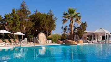 Una piscina al aire libre, sillones reclinables de piscina