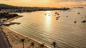 Una vista sulla costa con spiaggia, barche e uno skyline sullo sfondo.