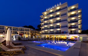 A multi-story hotel with a swimming pool, lounge chairs, and umbrellas. - Bellamar Hotel Beach & Spa (Sant Antoni de Portmany)