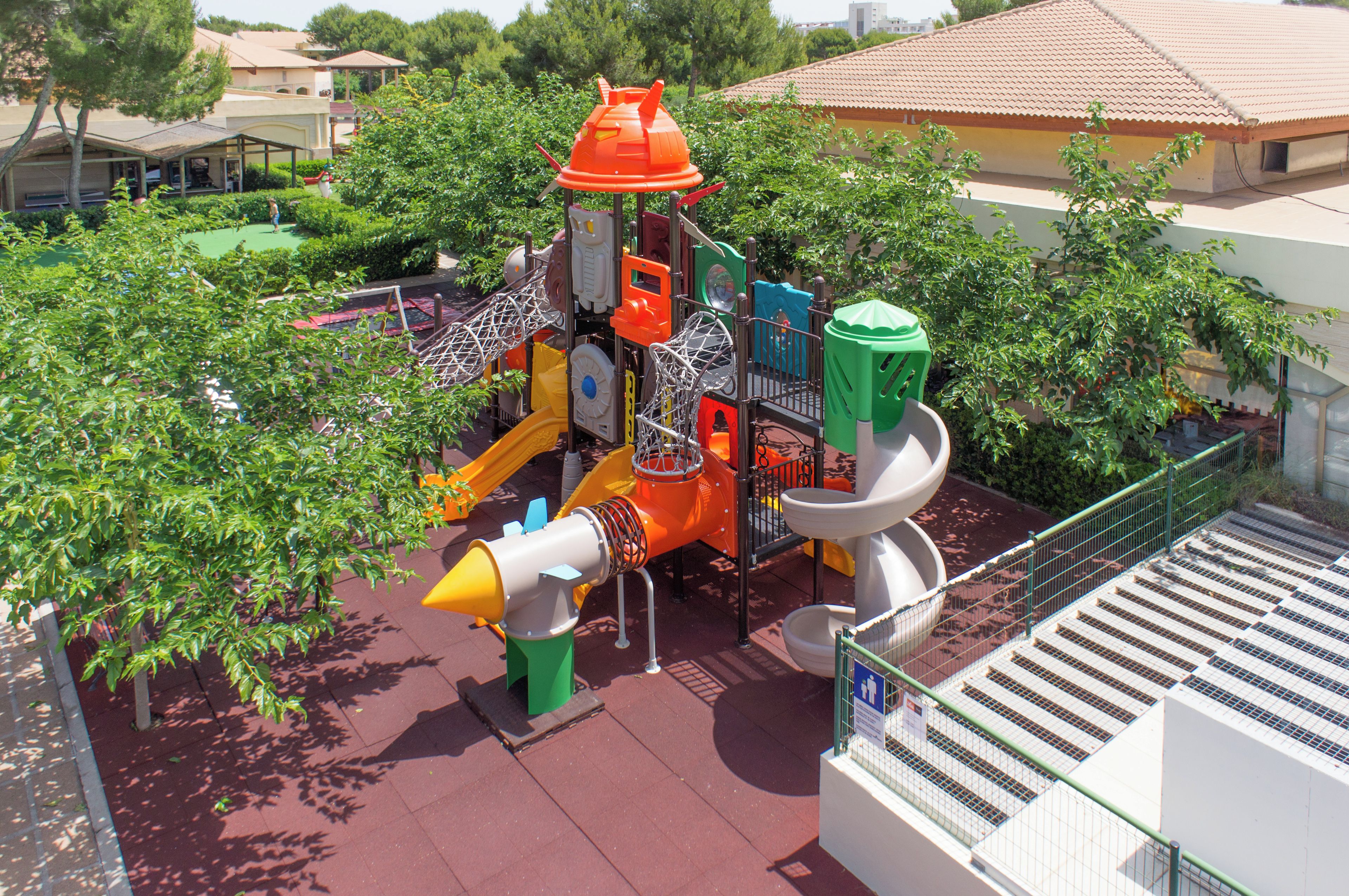 Un parque infantil con diversas estructuras de juego, incluyendo toboganes y zonas de escalada.