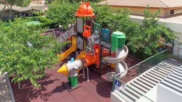 Un parque infantil con diversas estructuras de juego, incluyendo toboganes y zonas de escalada.