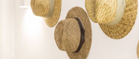 A wall with several straw hats displayed.
