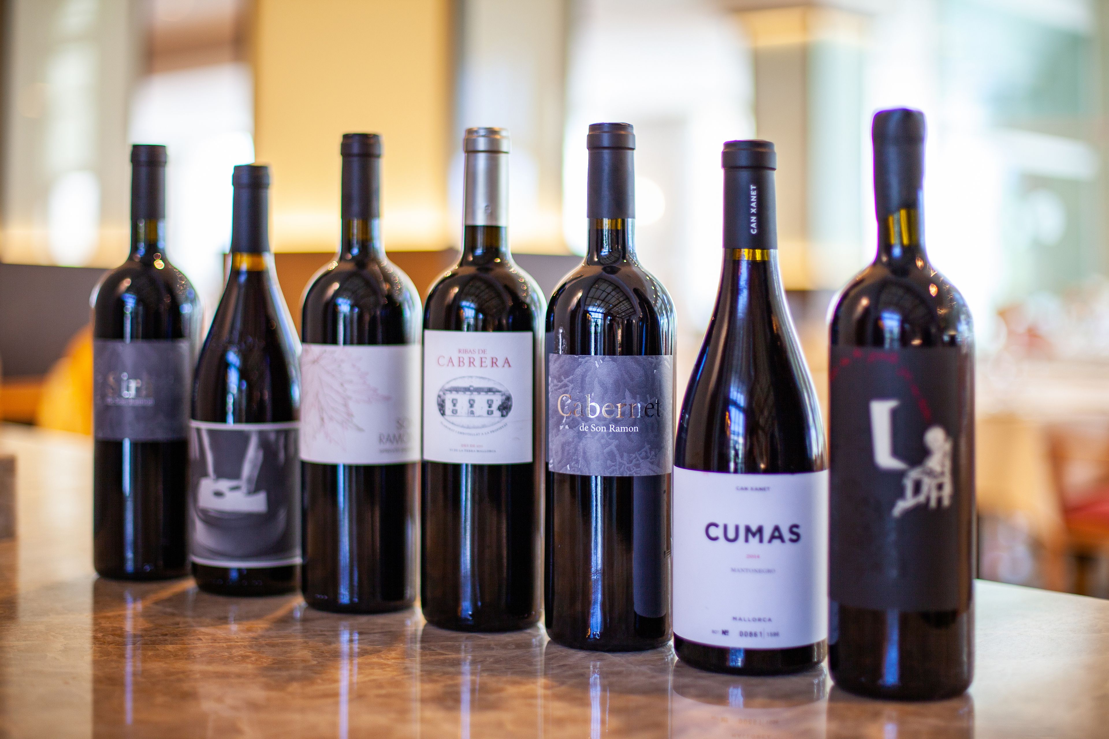 A row of wine bottles on a countertop.