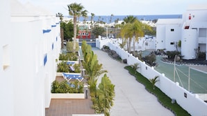 A coastal hotel with white buildings, a pool area, and a view of the sea. - Hotel Siroco - Adults Only (Teguise)