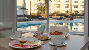 A breakfast table with plates of food, a cup, and a laptop. - Hotel Siroco - Adults Only (Teguise)