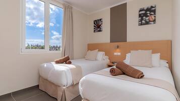Una habitación de hotel con dos camas, un ventanal con vistas y obras de arte en las paredes.