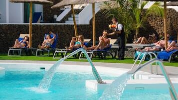A pool area with lounge chairs and umbrellas.