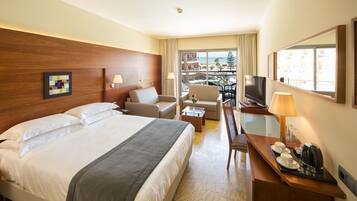 Une chambre d’hôtel avec un grand lit, un bureau avec une lampe, une chaise et un téléviseur.