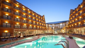 Ein Hotel mit einem großen, überdachten Innenpool, umgeben von Liegestühlen.