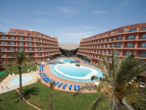 A hotel with a central pool surrounded by lounge chairs and palm trees. - Protur Roquetas Hotel & Spa (Roquetas de Mar)