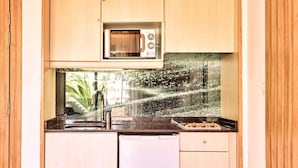 A compact kitchen with a built-in microwave, a sink, and a dishwasher. - Zafiro Palmanova (Calvia)
