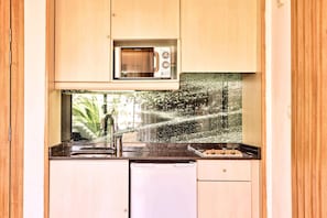 A compact kitchen with a built-in microwave, a sink, and a dishwasher. - Zafiro Palmanova (Calvia)