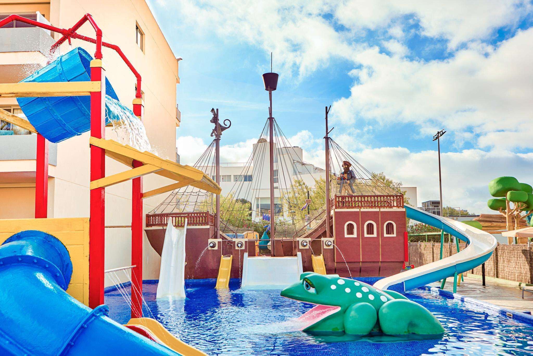 Un parco acquatico con scivoli e piscina, con un edificio a tema piratesco sullo sfondo.