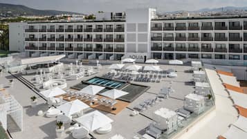 Een buitenzwembad, parasols voor strand/zwembad