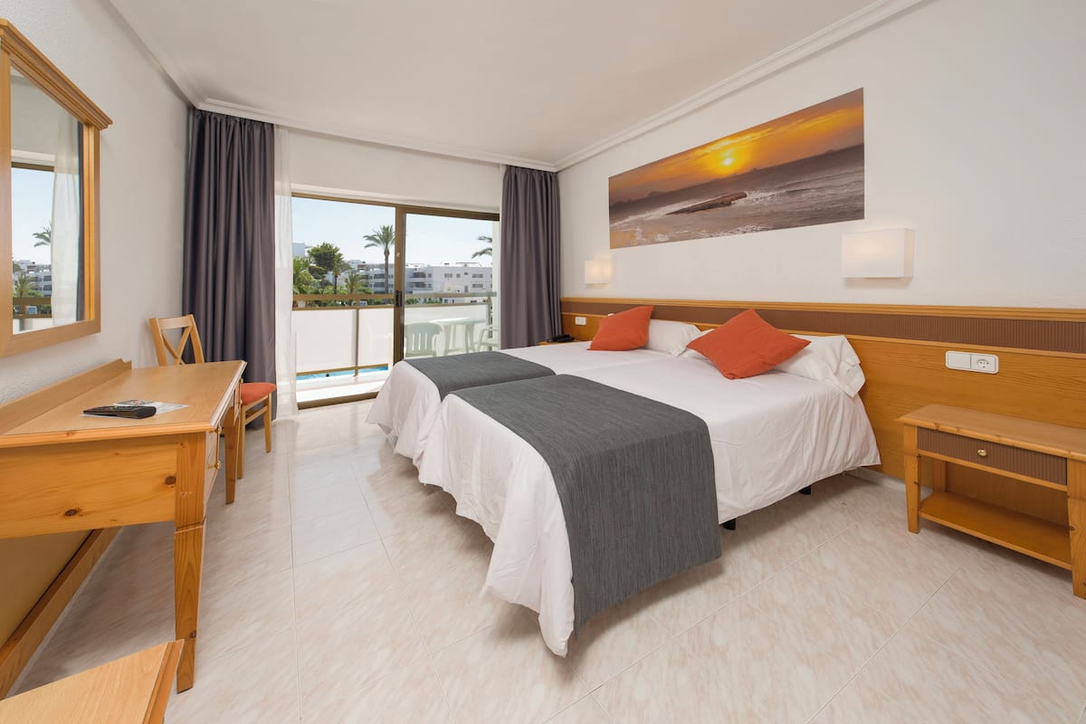 Una habitación de hotel con una cama grande, un escritorio y una silla.