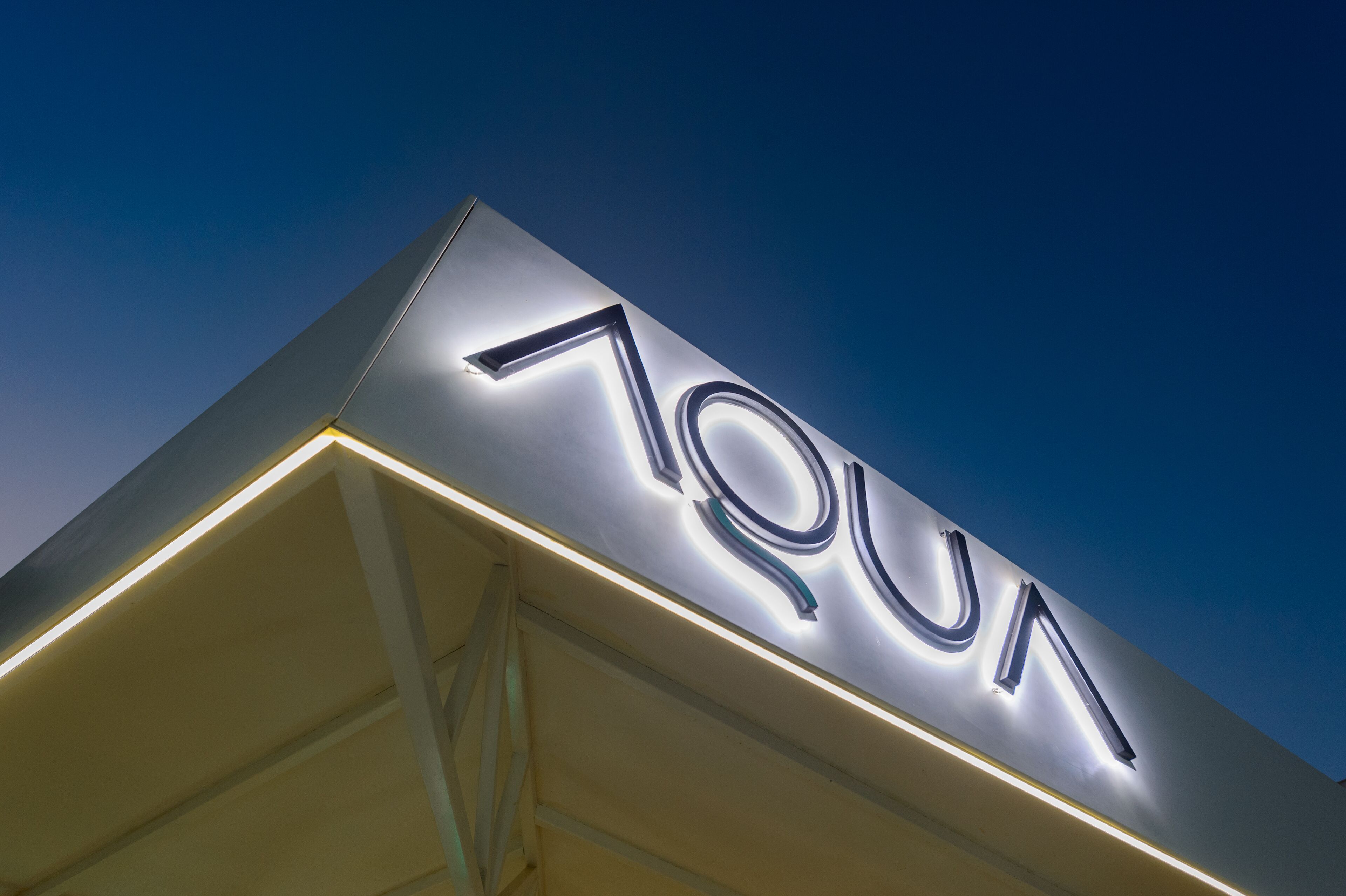 Ein Gebäude mit einer gut sichtbaren, beleuchteten Schrifttafel mit dem Schriftzug „AQUA“.