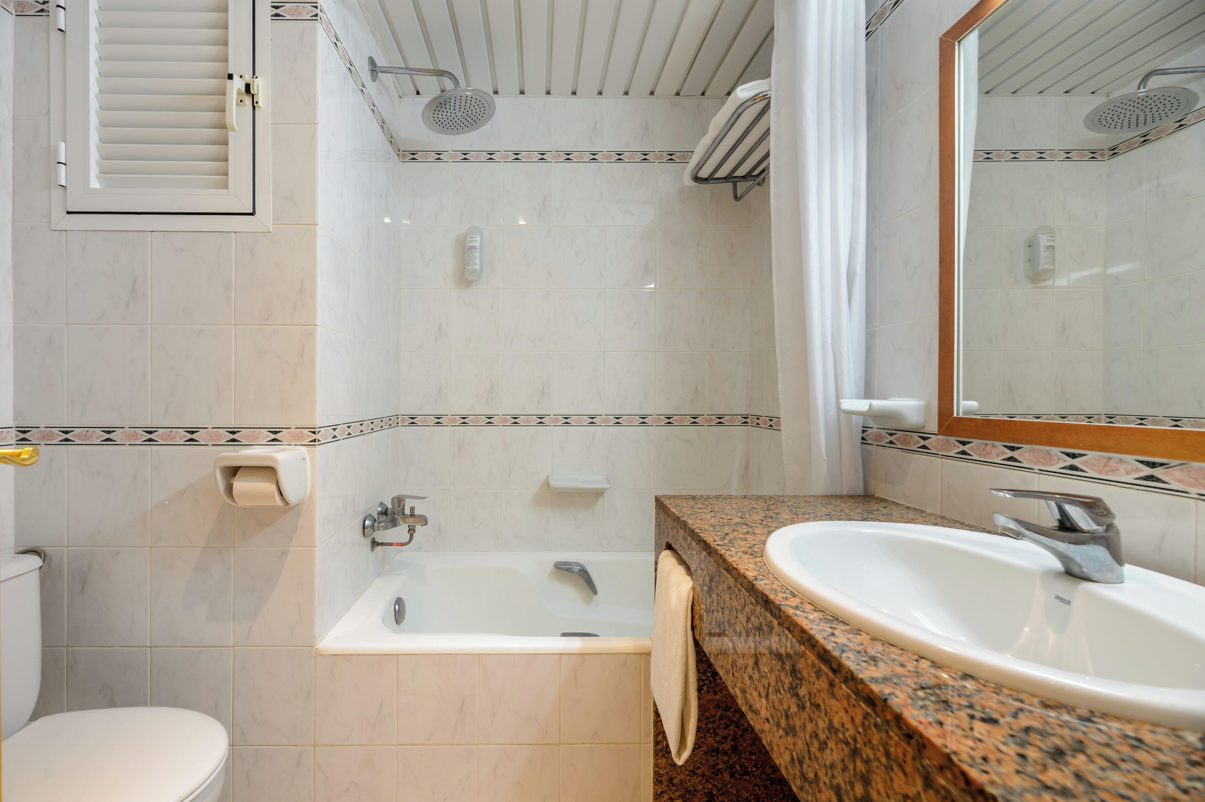 Un baño con bañera, lavabo e inodoro.
