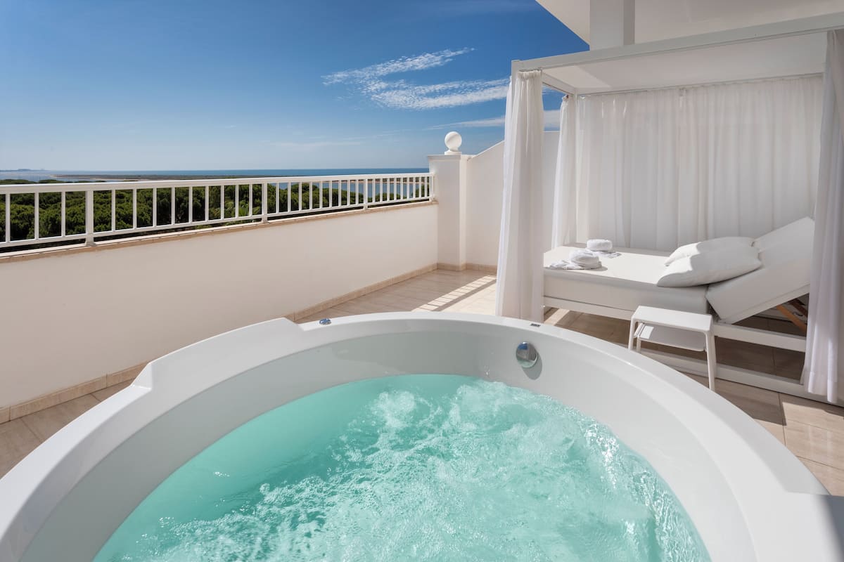 A hot tub on a balcony with a view of the sea.
