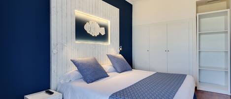 A modern bedroom with a bed, nightstand, and built-in wardrobe.