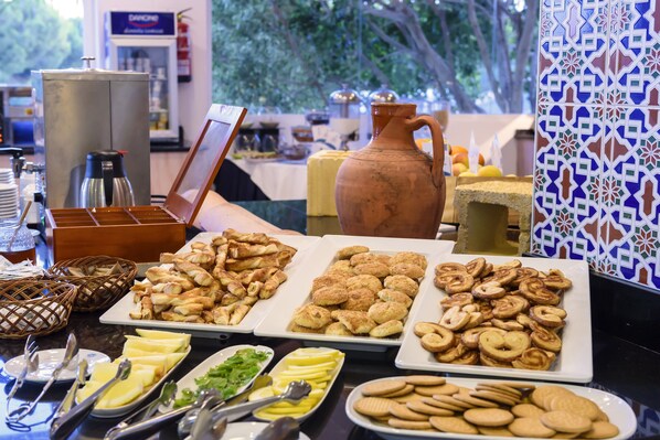 Una mesa de buffet con diversos alimentos y utensilios.