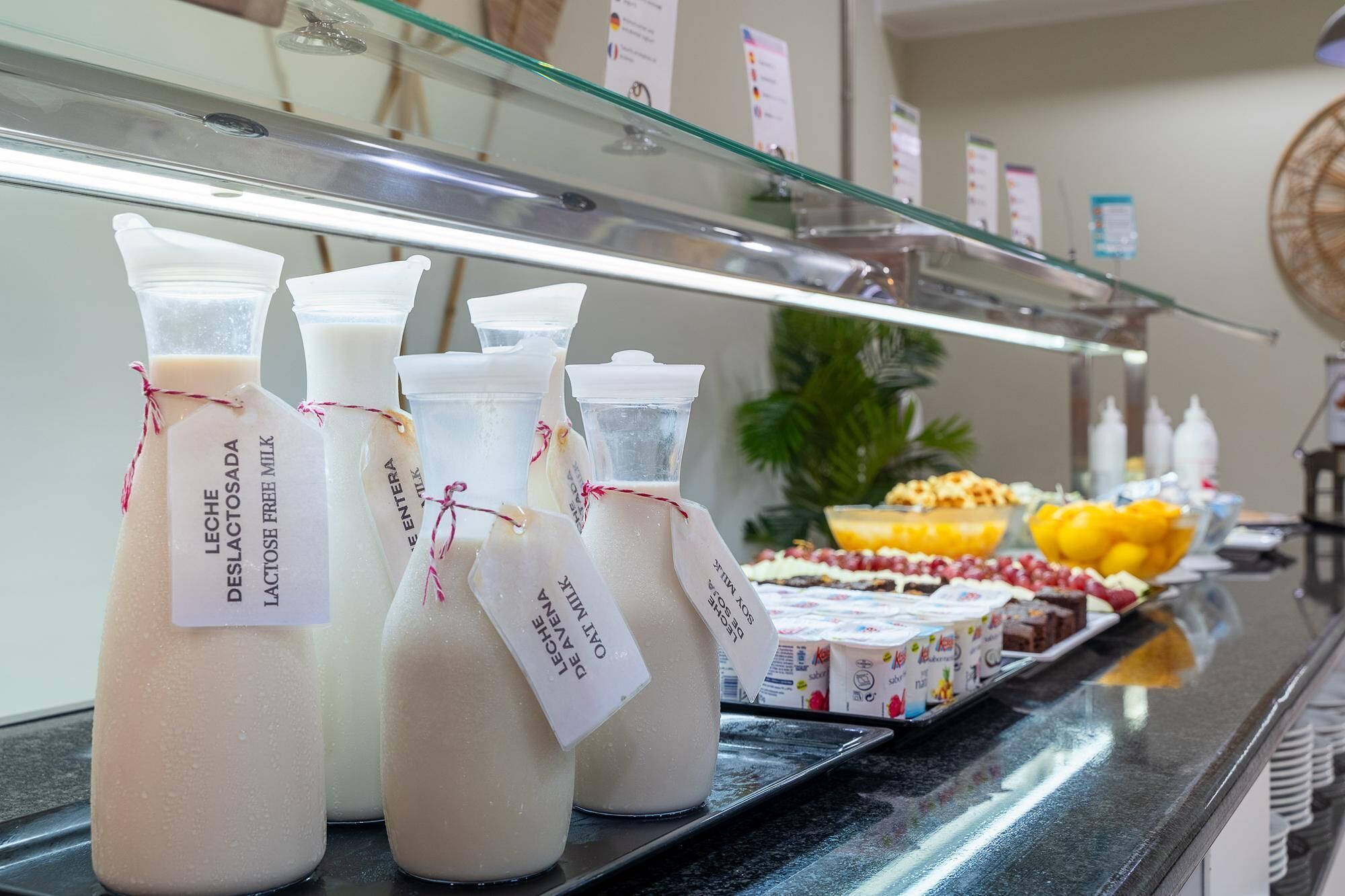 A buffet counter with various dairy products and desserts.