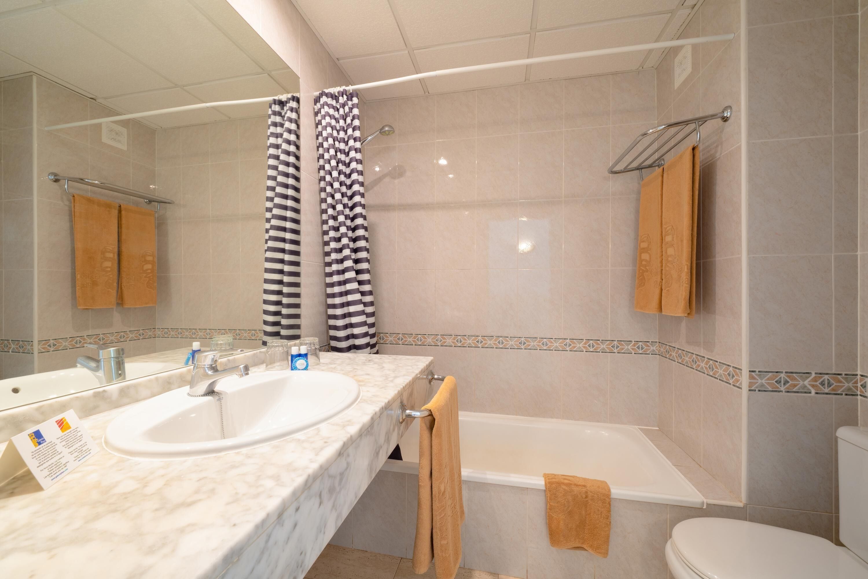 Un baño con lavamanos doble, bañera y retrete.