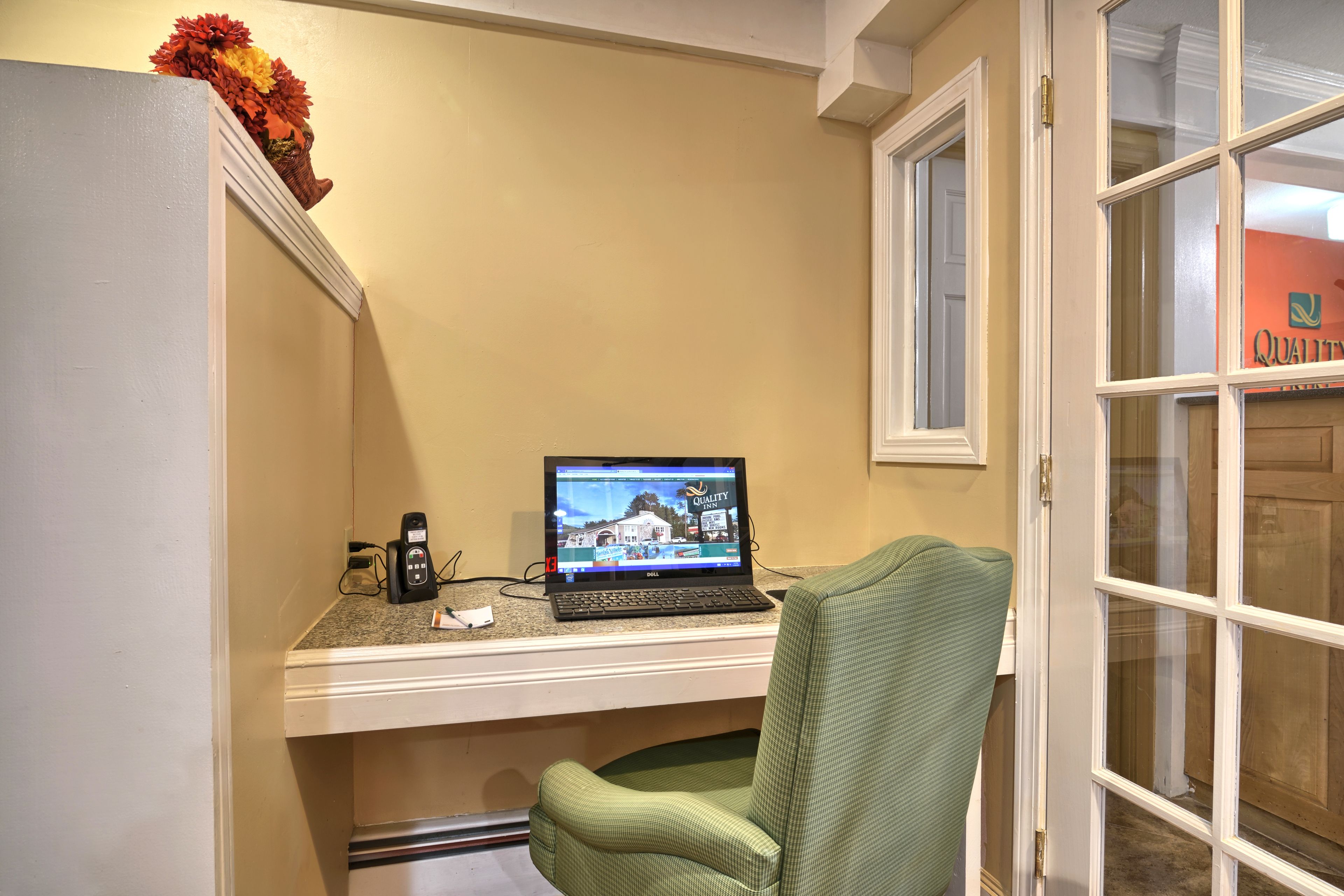 Une pièce comprenant un bureau, un ordinateur portable, un téléphone et une chaise.