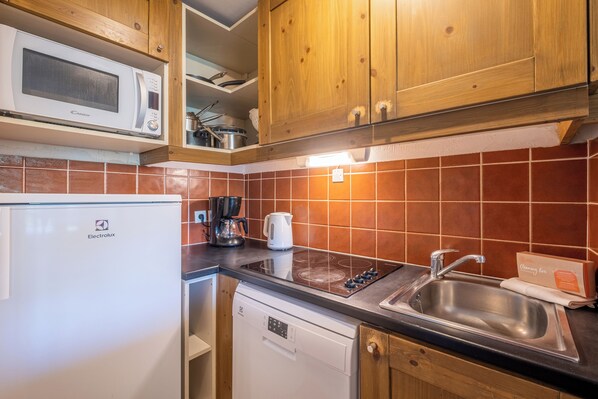 A modern kitchen with a microwave, stove, sink, and dishwasher.