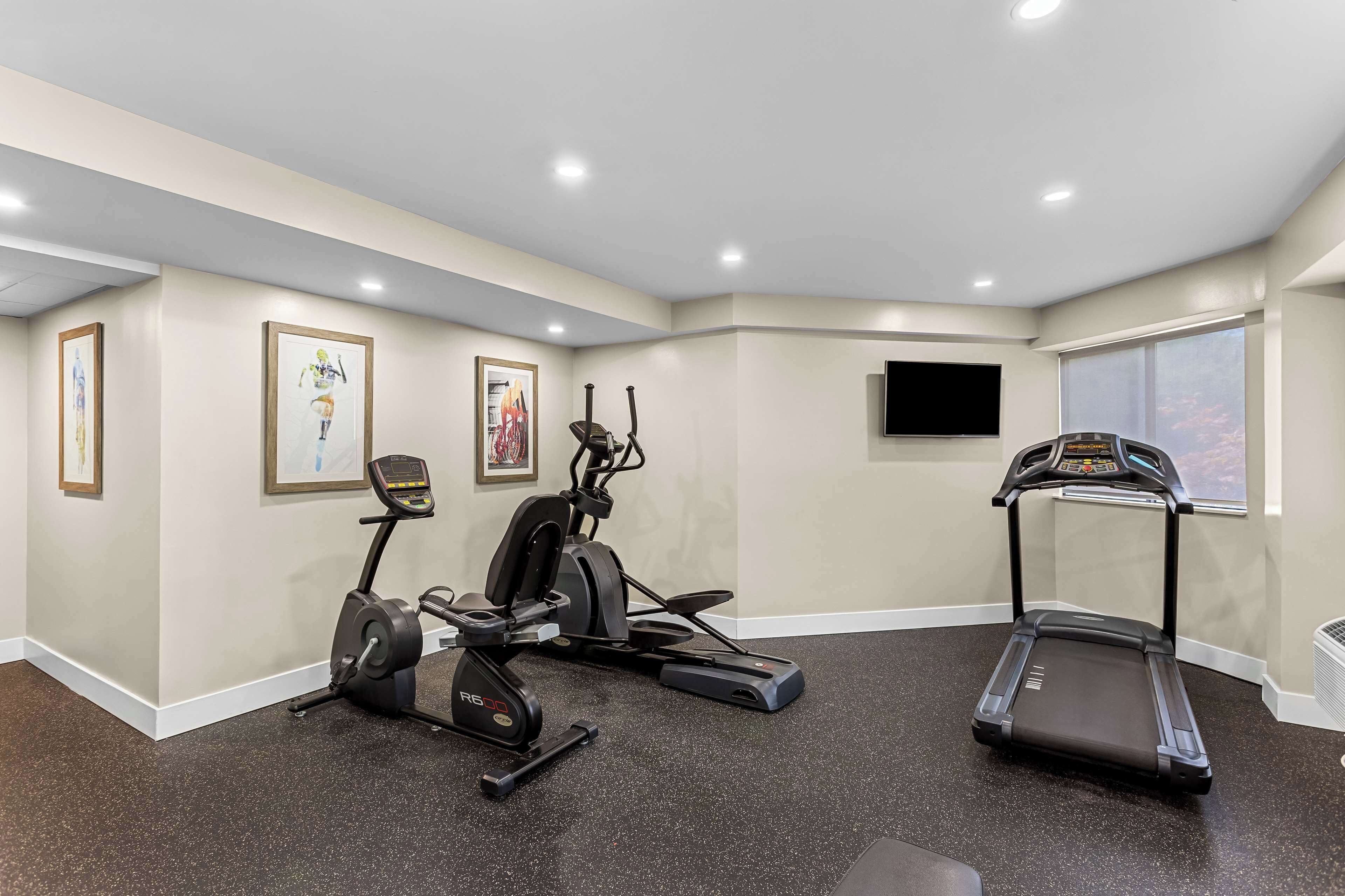 Gimnasio en casa con cinta de correr, elíptica y bicicleta estática.