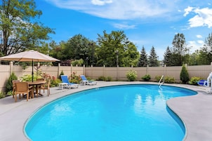Una piscina al aire libre, sillones reclinables de piscina