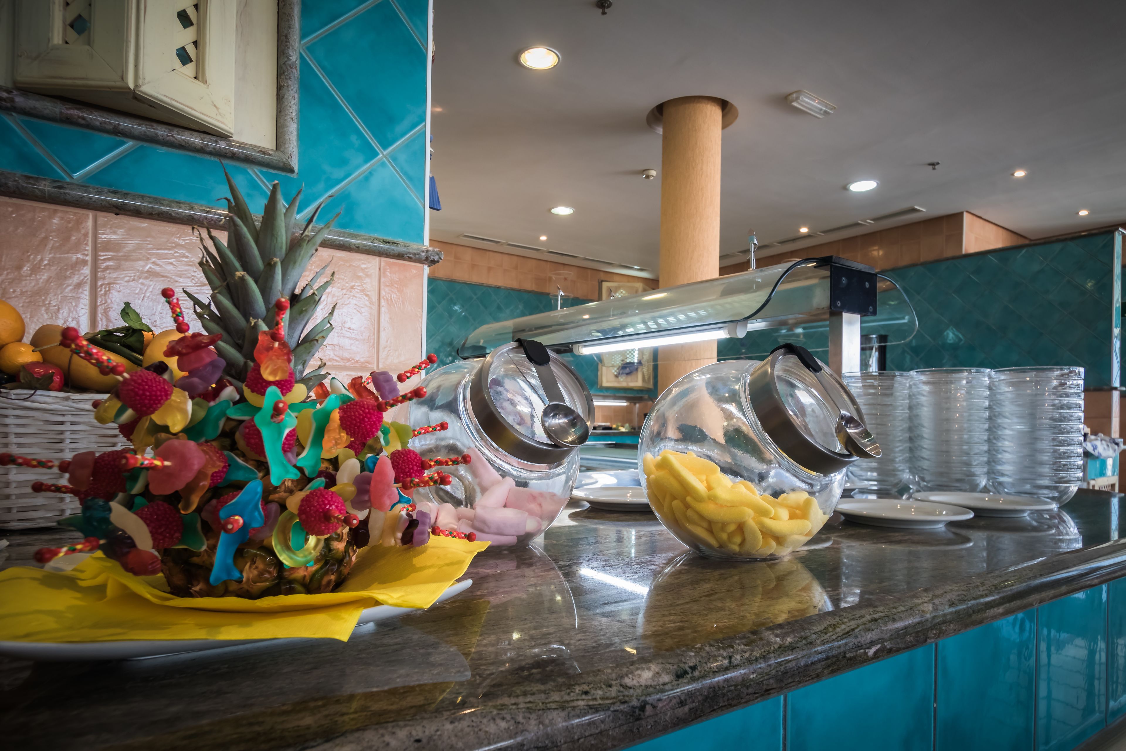 A breakfast bar with a variety of fruits and a coffee machine.