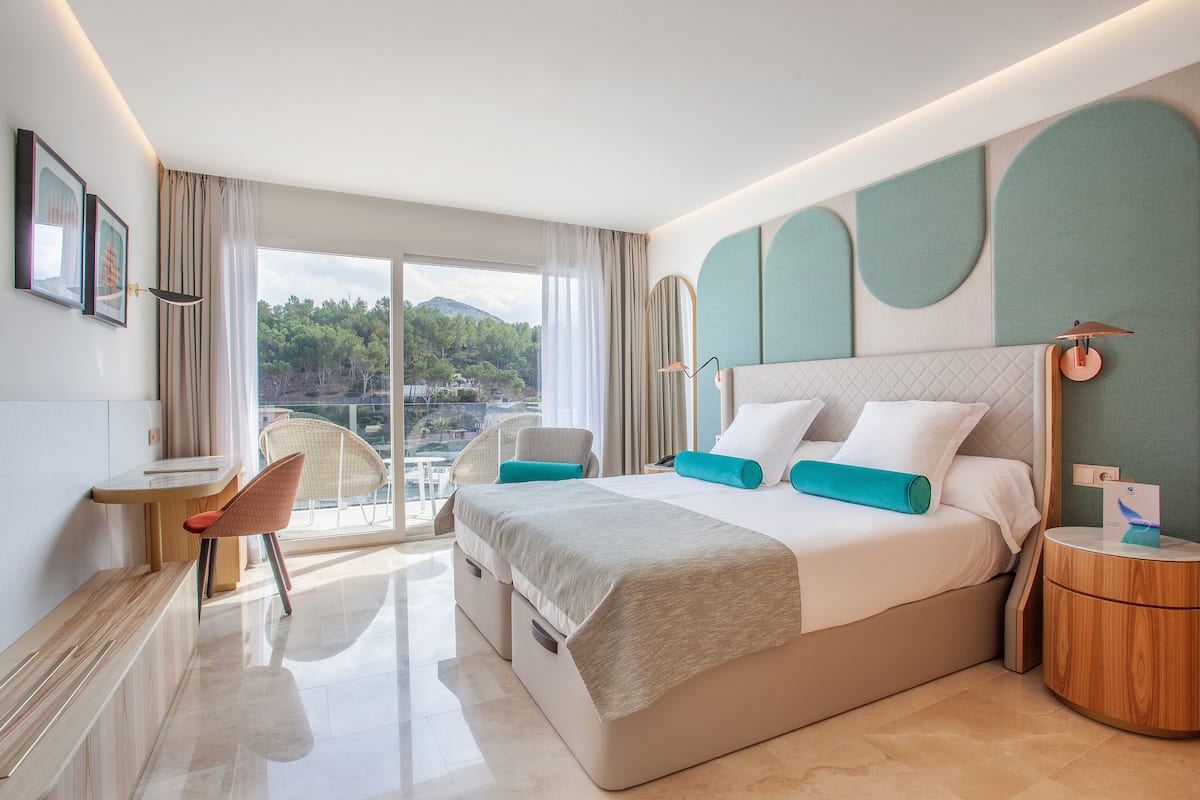Una habitación de hotel moderna con una cama grande, un escritorio y una silla.
