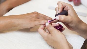 Ein Nahaufnahme von Händen, die Nagellack auftragen.