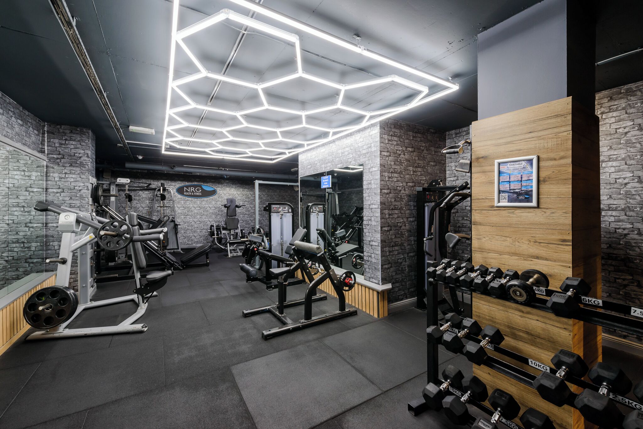 Een sportschool met diverse fitnessapparaten, waaronder krachttoestellen en gewichten.