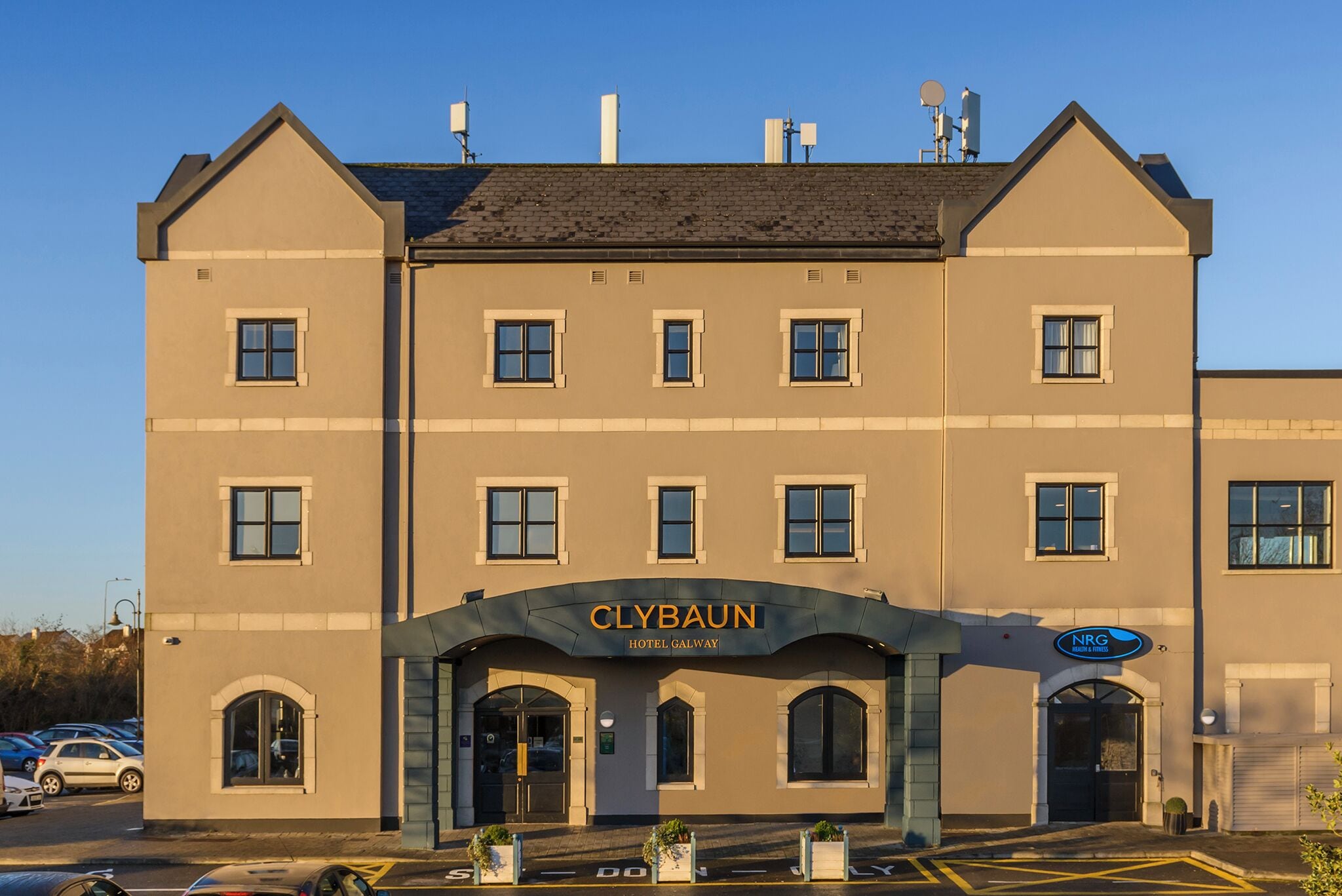 Un hôtel avec une enseigne bien visible indiquant « Hôtel Clybaun, Galway », ainsi qu’une enseigne pour un centre de santé et de remise en forme.