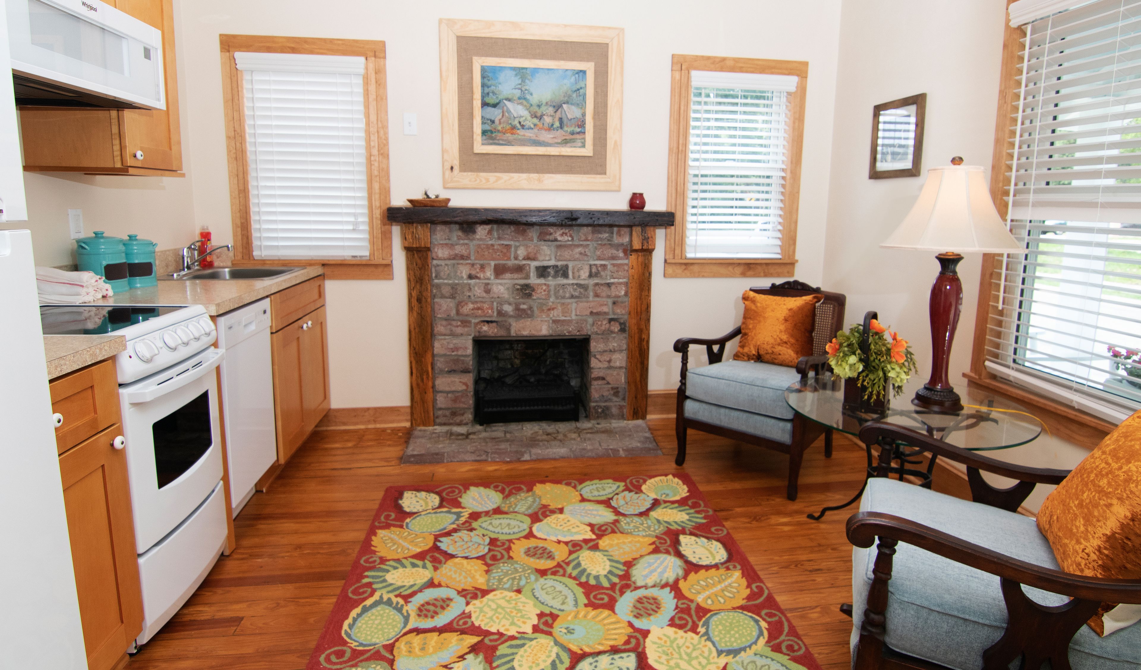 A cozy living room with a fireplace, a dining area, and a kitchen with modern appliances.