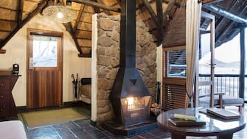 A rustic interior with a stone fireplace, wooden beams, and a checkered floor.