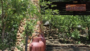 Un muro de piedra con grandes jarrones y un letrero que dice 'TSHUKUDO'.