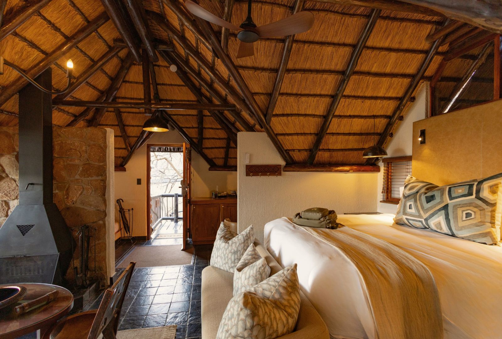 Um quarto acolhedor com cama, lareira e parede de pedra.