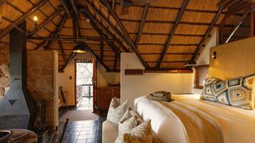 Um quarto acolhedor com cama, lareira e parede de pedra.