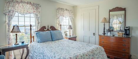A bedroom with a bed, dresser, and two lamps.