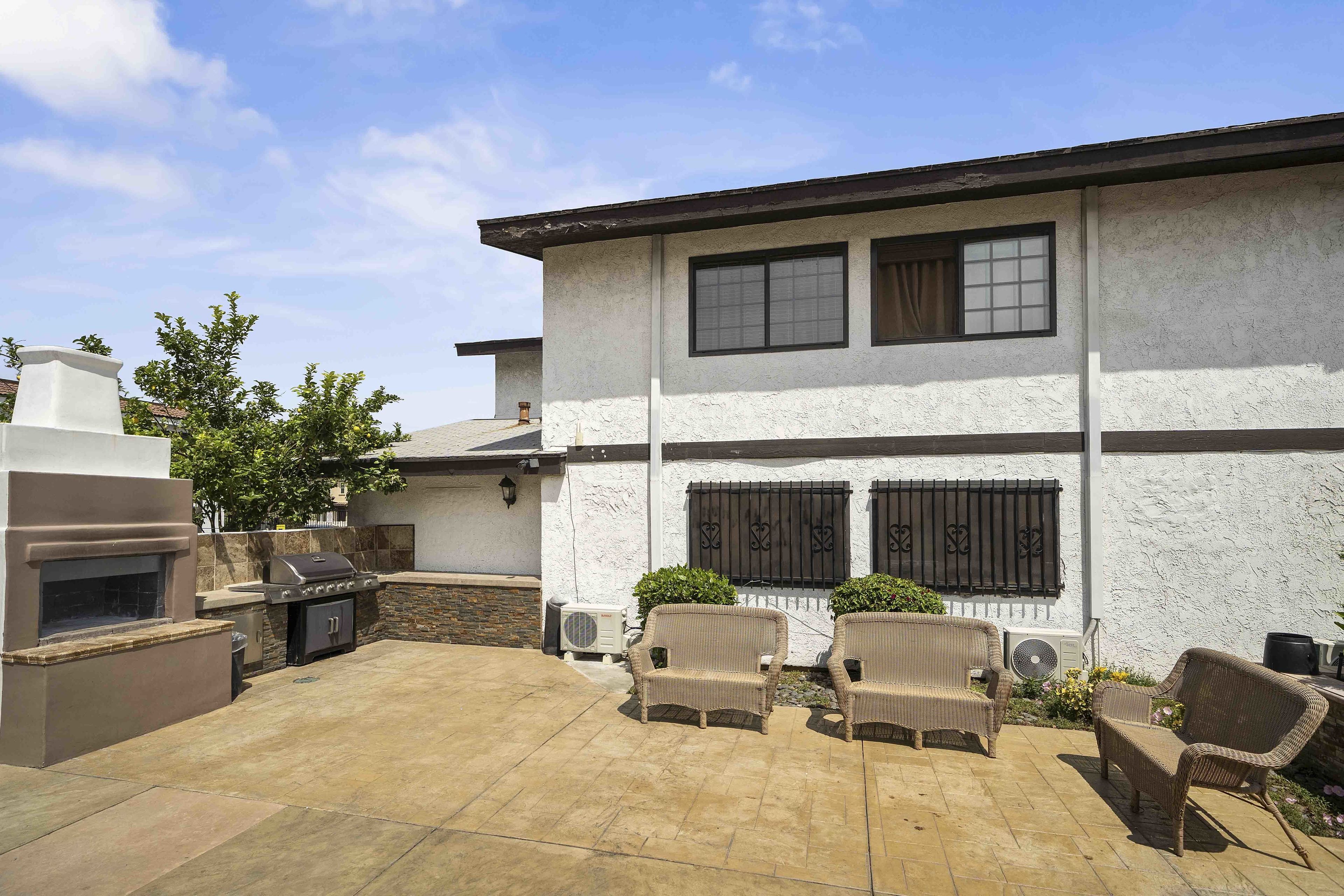 A patio with outdoor furniture and a barbecue grill.